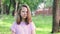 Portrait of angry young girl. Girl looking to the camera with a displeased face. City park on a sunny summer day