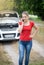 Portrait of angry young woman calling car service on the countryside road