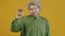 Portrait of annoyed person making bla bla bla hand gesture and moving mouth standing on yellow background