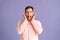 Portrait of annoyed young man covering ears with hands say blah blah do not wanna listen on pink isolated background in