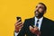 portrait of anxious stressed expressive bearded gentleman in suit and tie with smartphone video call hand up yellow