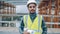 portrait of Arab construction specialist in helmet standing in building site holding plan