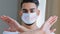 Portrait of arab hispanic man in medical protective mask with inscription no vaccine crosses arms in front of him