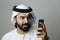 Portrait Of An Arab Male Model Using Mobile And Wearing UAE Emirati Traditional Dress   ARAB MODEL BUSINESS MOBILE