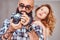 Portrait of an Arabian bearded male holding a camera and his beautiful redhead girlfriend.
