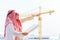 Portrait of arabian engineer talking about saudi job and verify the blueprint with commitment to success at construction site with