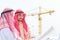 Portrait of arabian engineer talking about saudi job and verify the blueprint with commitment to success at construction site with