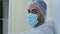 Portrait Arabic Spaniard doctor man surgeon medical worker wears protective clothing uniform face mask and cap feels