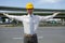 Portrait of architect in hardhat with arm raised at construction