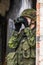 Portrait of armed woman with camouflage. Young female soldier observe with firearm