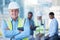 Portrait, arms crossed and a senior man construction worker outdoor on a building site with his team in the background