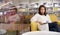 Portrait of Asain pretty cheerful female cozy sitting on sofa and reading a book in library with calm and happy. Mature woman