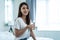 Portrait of Asian attractive woman holding a glass of water in bedroom. Young thirsty beautiful girl carry clean mineral natural