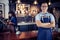 Portrait of asian barista with arms crossed at counter in coffee