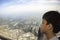 Portrait Asian boy looked at the view outside the plane window Background  City and the sky view