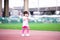 Portrait of Asian child girl running on sport stadium. Children act embarrassed. Kid wear pink t shirts. Baby aged 4-5 years old