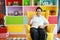 Portrait of asian confident grandfather sitting on yellow sofa in living room showing thumb up meaning ok or like with relaxation