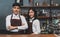 Portrait of Asian couple partnership barista standing with arms crossed looking at camera at counter bar in cafe, Service mind and