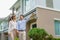 Portrait of Asian couple walking and hugging together looking happy in front of their new house to start new life. Family, age,