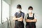 Portrait of Asian Craftsman or Carpenter worker man and woman wear safety helmet and protective mask, crossed arm and look at
