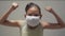 Portrait asian cute girl wearing protective mask during staying home. Female teenager show her strength and looking at camera.