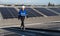 Portrait of Asian engineer on background field of photovoltaic solar panels solar cells on roof top factory.