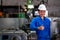 Portrait of Asian factory worker woman shows thumbs up and stand in front of machine in workplace area. Management and support