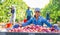 Portrait of a Asian farmer woman squatting near a crate of ripe plums