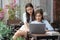 Portrait of Asian female best friend sitting using laptop on the balcony outside the house. Two happy women while shopping online