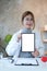 Portrait of asian female doctor holding mock up digital tablet and smiling to camera. Blank screen for your advertising text