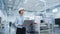 Portrait of an Asian Female Engineer in Hard Hat Standing and Using Laptop Computer at Electronic