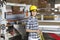 Portrait of an Asian female industrial worker with holding wire with machinery in background