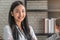 Portrait of Asian female student with bookshelf in library