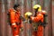 The portrait of Asian firefighters are wearing orange fire protection uniform mask and helmet front of building.