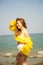Portrait Asian girl long hair, bikini two-tone white and yellow, standing post happy posture by the sea, in Thailand South Asia,