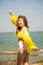 Portrait Asian girl long hair, bikini two-tone white and yellow, standing post happy posture by the sea, in Thailand South Asia,