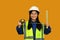 Portrait of Asian girl posing as an engineer or architect on yellow background. Dream occupation, future profession and