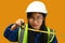 Portrait of Asian girl posing as an engineer or architect on yellow background. Dream occupation, future profession and