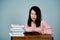 Portrait of an Asian girl wearing a pink shirt. reading a book With a very thoughtful and stressful expression behind the studio