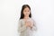 Portrait of Asian little girl holding hands on heart gesture of love. Kid place arms on chest isolated on white background