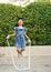 Portrait of asian little girl jumping rope in the park
