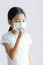 Portrait of Asian little girl wearing a protective medical mask and coughs