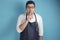 Portrait of Asian male chef or waiter put finger on his mouth, ask to be silent, keep secret gesture
