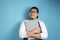 Portrait of Asian male chef or waiter smiling and thinking while holding clipboard, successful entrepreneur in good restaurant