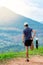 Portrait of an Asian male runner in a blue shirt and hat standing warm up in preparation for a jogging run. It is located on a