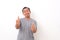 Portrait of Asian man stand happy and positive with thumbs up approving with a big smile and funny face expressing okay gesture