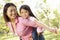 Portrait Asian mother and daughter playing in park