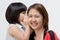 Portrait of Asian mother whispering to her daughter