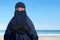 Portrait of asian muslim woman in hijab with niqab with ocean