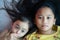 Portrait of Asian sisters siblings close up face on concrete background